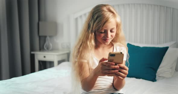 Girl Texting on Smartphone in Bedroom