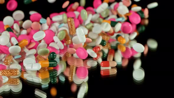 Super Slow Motion Shot of Falling Colorful Pills on Black Background at 1000Fps alt