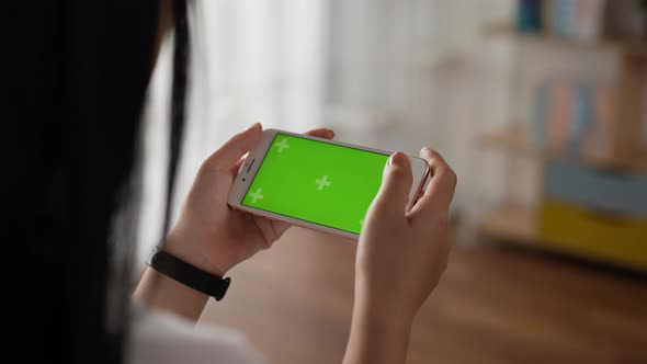 Closeup horizontal of hand woman holding smartphone with green screen alt