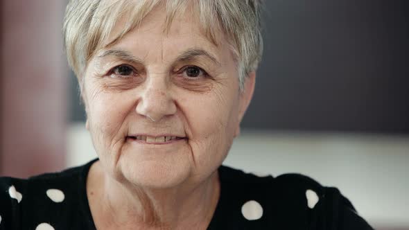 happy old woman smiles to the camera alt