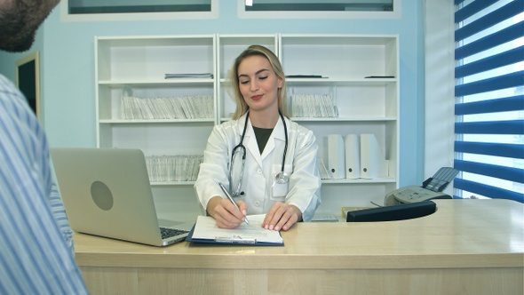 Smiling nurse with laptop scheduling appointment for male