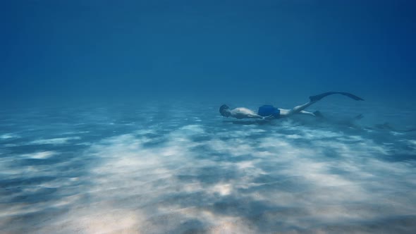 Man Swimming Undersea on Sandy Seabed alt