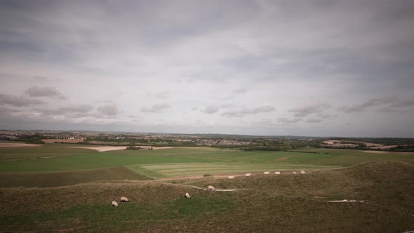 Timelapse of Dorchester and Poundbury in Dorset. From the top of Maiden Castle. People and sheep can alt