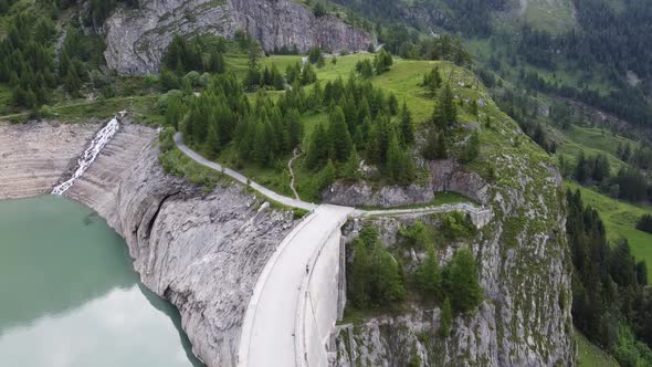 Bird's-eye view of the large dam of the green lac de tseuzier in the swiss alps alt