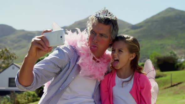 Smiling father and daughter in fairy costume taking selfie with mobile phone 4k alt