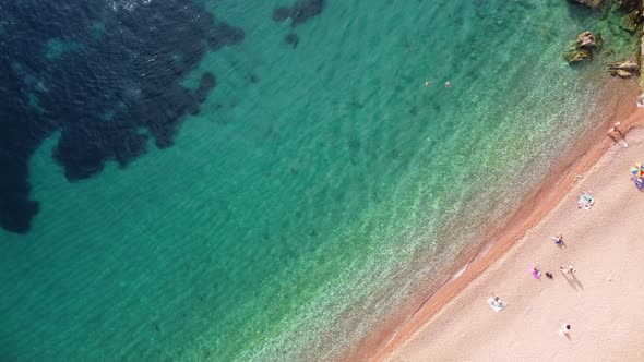 Aerial top real view of white sand beach with crystal clear sea