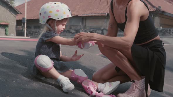Woman Preparing Her Daughter for Roller-skating alt