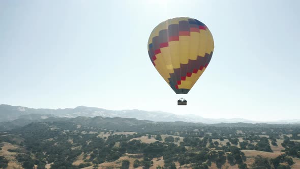 Colorful Hot Air Balloon Epic Flying in Blue Sky with Mountains on Background alt