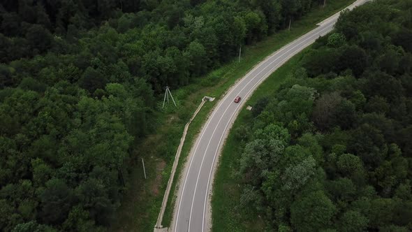 Drone Point of View Tracking Mode Aerial View Flying Over Two Lane Countryside Forest Road with alt