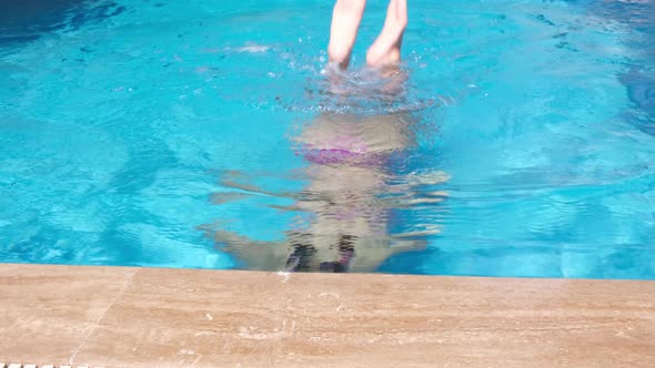 Cute Girl in Pink Water Glasses in the Swimming Pool