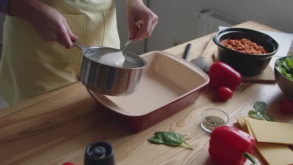 Woman Is Putting Sauce Into Ovenware