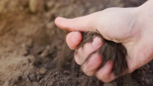 The Hand Rubs Soft Loose Soil Closeup alt