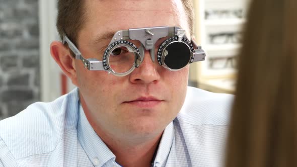 A Man Having Conducted an Eye Exam By Optician. Choosing Proper Lenses in the Goggles