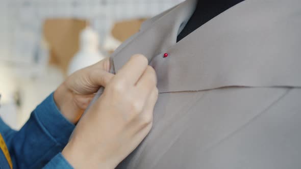 Closeup of Female Hands Sewing New Fashionable Clothing on Tailor's Dummy in Workshop alt