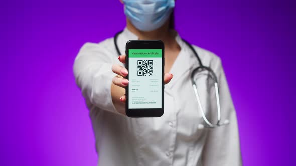 Woman Doctor in Medical Uniform Showing Vaccination Passport with Qr Code on Phone International alt