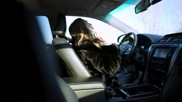 Side View of Angry Depressed Caucasian Young Woman Kicking Steering Wheel in Slow Motion and Crying alt