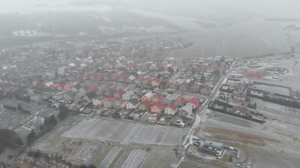 Aerial forward towards snow covered residential houses in suburb during snow storm alt