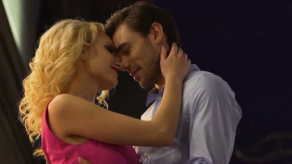 Blond Woman and Attractive Man on Date Hugging, Man Kissing Womans Ear, Passion alt