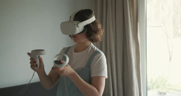 Woman in VR Goggles Playing Game at Home alt