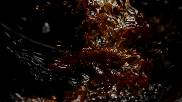 Dark Sparkling Liquid Pouring Splashing in Slow Motion on Black Background