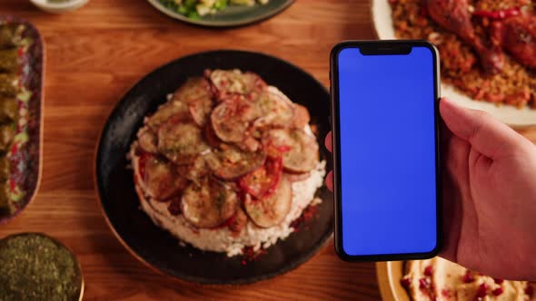 Maqluba Hummus Dolma Kabsa Tabbouleh Closeup Smartphone with Blue Chroma Key Screen Middle Eastern alt