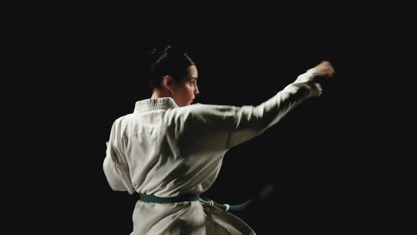 Young Woman in Kimono Practicing Karate alt