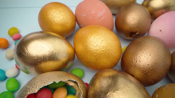 Easter Eggs Painted in Gold Color on Blue Wooden Table Close Up