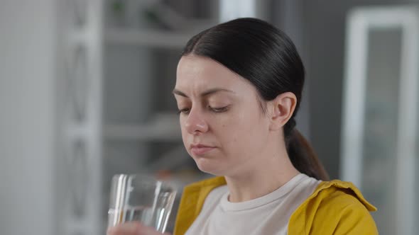 Closeup Young Woman Taking in Medications Washing Off Pills with Water alt