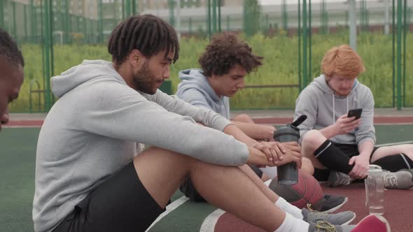 Male Friends Relaxing after Streetball Game alt