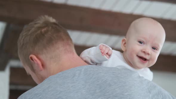 happy baby on dad’s shoulder