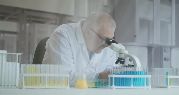 Bearded Caucasian Male Researcher Wearing Protective Glasses and Working with a Microscope Spbas alt