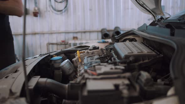 Auto Mechanic Pours Car Oil Into Car Engine