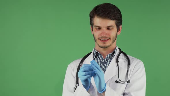 Handsome Bearded Male Doctor Putting on Medical Rubber Gloves alt