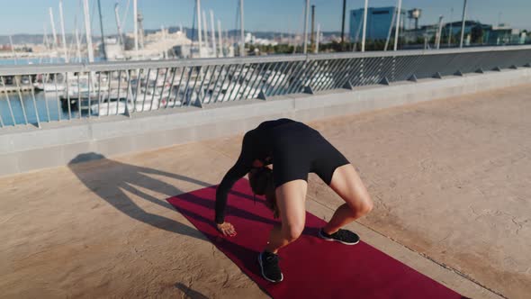 Flexible Woman Doing Wheel Pose on Embankment alt
