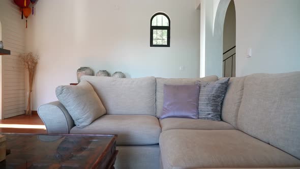 Moving Shot Over a Sofa with Some Pillows on a Modern Living Room to Show a Staircase on the Back