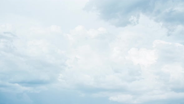 Timelapse of white fluffy clouds. Aerial view of light blue sky