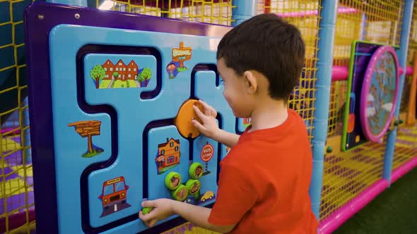 A Fiveyearold Little Boy Playing a Puzzle Game at an Amusement Park