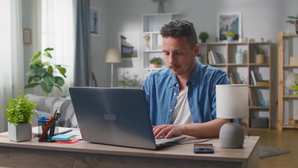 A Young Man Opens a Laptop and Starts Typing alt