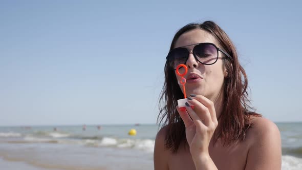 Female on ocean beach   blowing soap bubbles  slow-mo 1920X1080 HD video - Happy and beautiful young alt