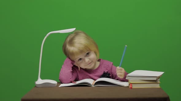 Girl Drawing at the Table. Education Process in Classroom. Chroma Key alt