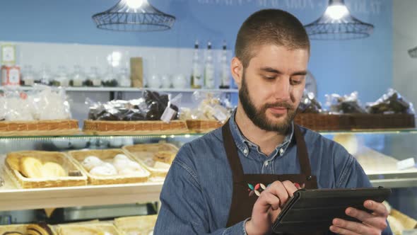 Handsome Professional Male Baker Using Digital Tablet at His Store