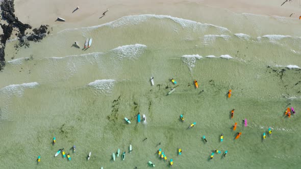 People who enjoy surfing on clear and transparent beaches alt