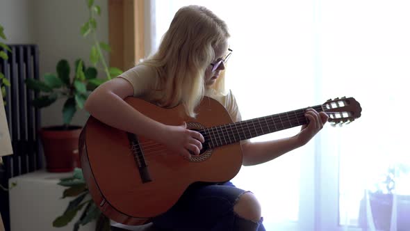 Teenage Girl Playing Guitar at Home Closeup
