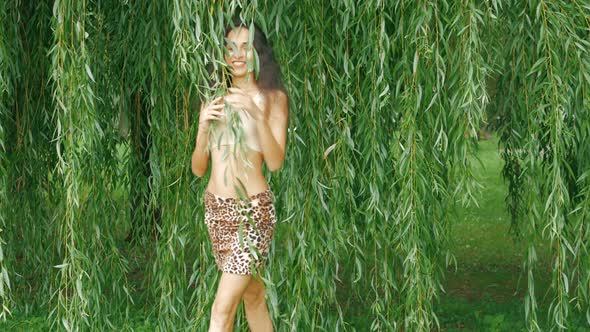 a mixed race woman walks among the willow leaves