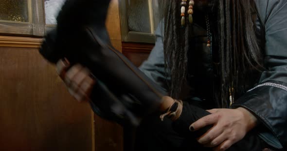 Pirate Captain Takes Off Black Boot From Wooden Leg in Cabin alt