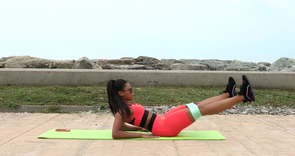 Active fitness young woman working out abdominals.