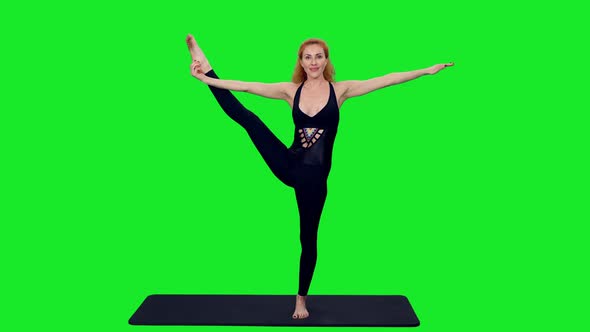 Sporty Woman Doing Yoga Exercises on Mat Against Green Screen