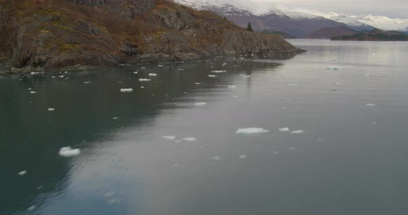 Aerial closeup shot of Troopers helicopter flying over tundra, ponds, winter vegetation, at golden h