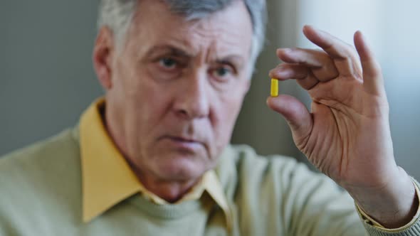 Unhealthy Old Senior Retired Male Caucasian Sick Ill Patient 60s Grandfather Man Holds Pill with alt