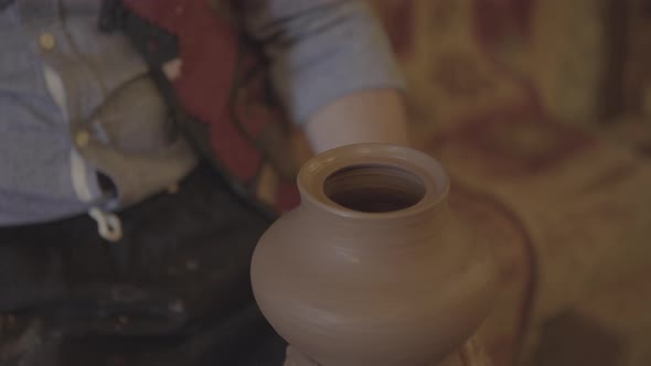 Closeup Front View of Potter's Hands Working and Making Clay with Wet Clay on a Pottery Wheel - 1